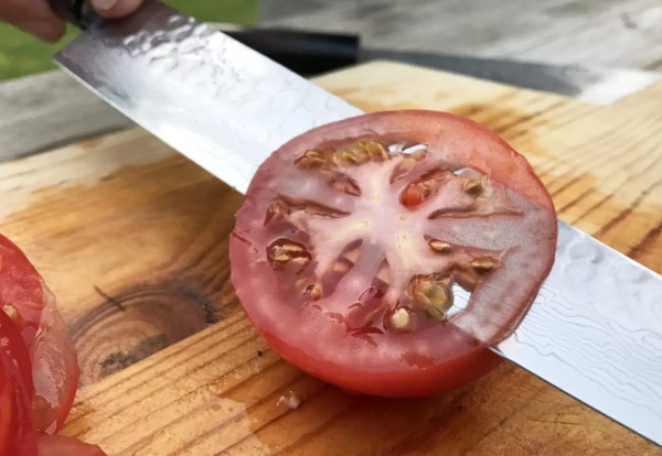 Нож режет помидоры